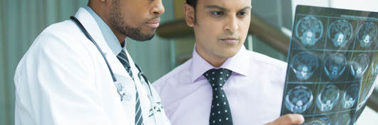 Two doctors examining a brain x-ray