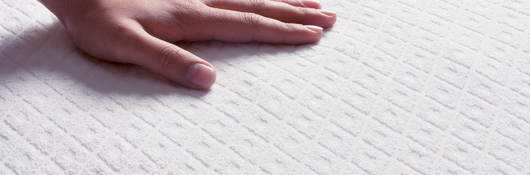 Human hand touching a mattress top
