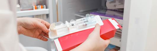 Doctor retrieving vaccine from refrigerator.