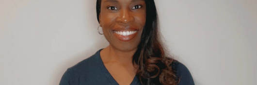 Denice Durrant smiles proudly in a beautiful blue sweater.