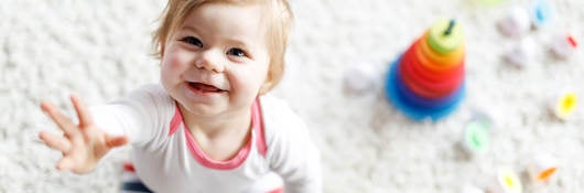 Smiling child surrounded by toys.