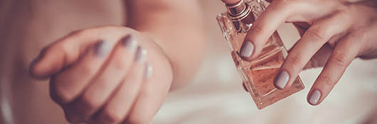 Woman spraying perfume on wrist
