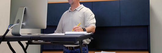 Man using stand up desk in office for good health