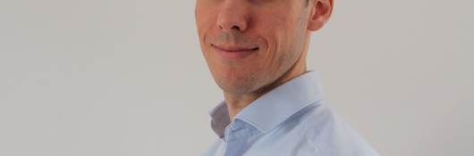 Headshot of Pierre-Marie Doitrand, standing at an angle and wearinga light blue button down shirt