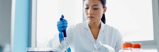 worker in laboratory using dropper