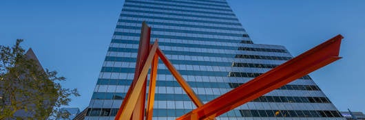 Skyscraper with red sculpture in the foreground