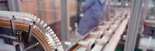 A syringe factory with a worker in the background