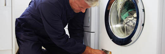 Repairman working on clothing dryer
