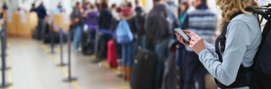 Person using cellphone in line at the airport
