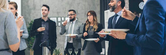 Group of businesspeople eating at a business conference event 