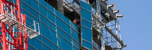 Lifting glass into place while constructing a commercial building