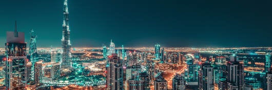 Nighttime Dubai skyline with illuminated skyscrapers