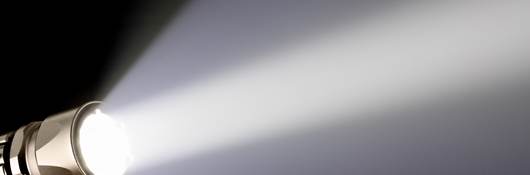A piercing beam of light from a handheld flashlight.
