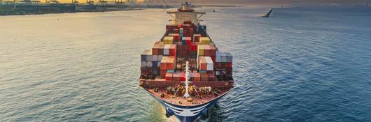 Aerial front view of a container cargo ship for import export, shipping or freight transportation.