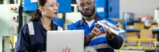 Two people looking over a device.