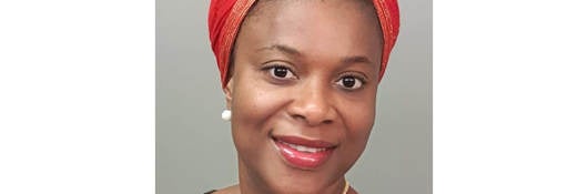 Closeup of Omokhuwa Omosotome in red hair wrap. 