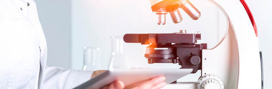 Scientist reviewing notes next to a microscope