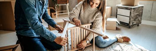 Young couple assembling furniture for new home