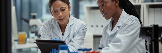 Shot of two scientists working together on a digital tablet in a lab.