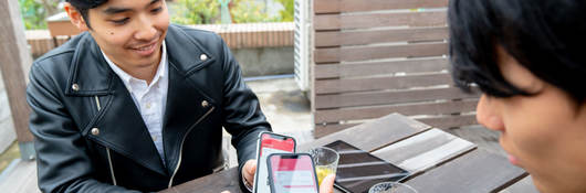 Two people demonstrating mobile to mobile payment transfer