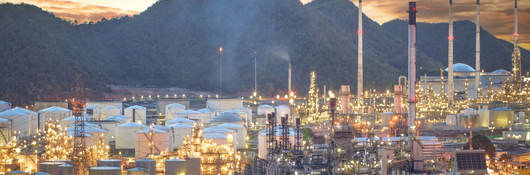 Oil refinery, aerial petrochemical storage tanks with refining industrial floor, oil refinery at night.