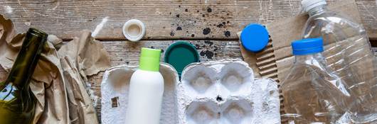 Various types of garbage for recycling on a wooden background.