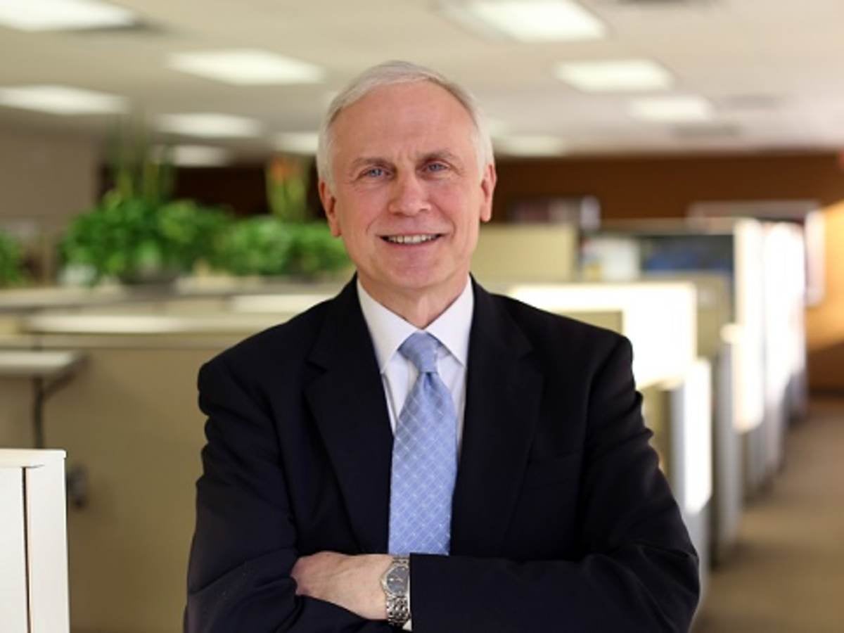 Bruce Bailey standing with arms crossed in office setting