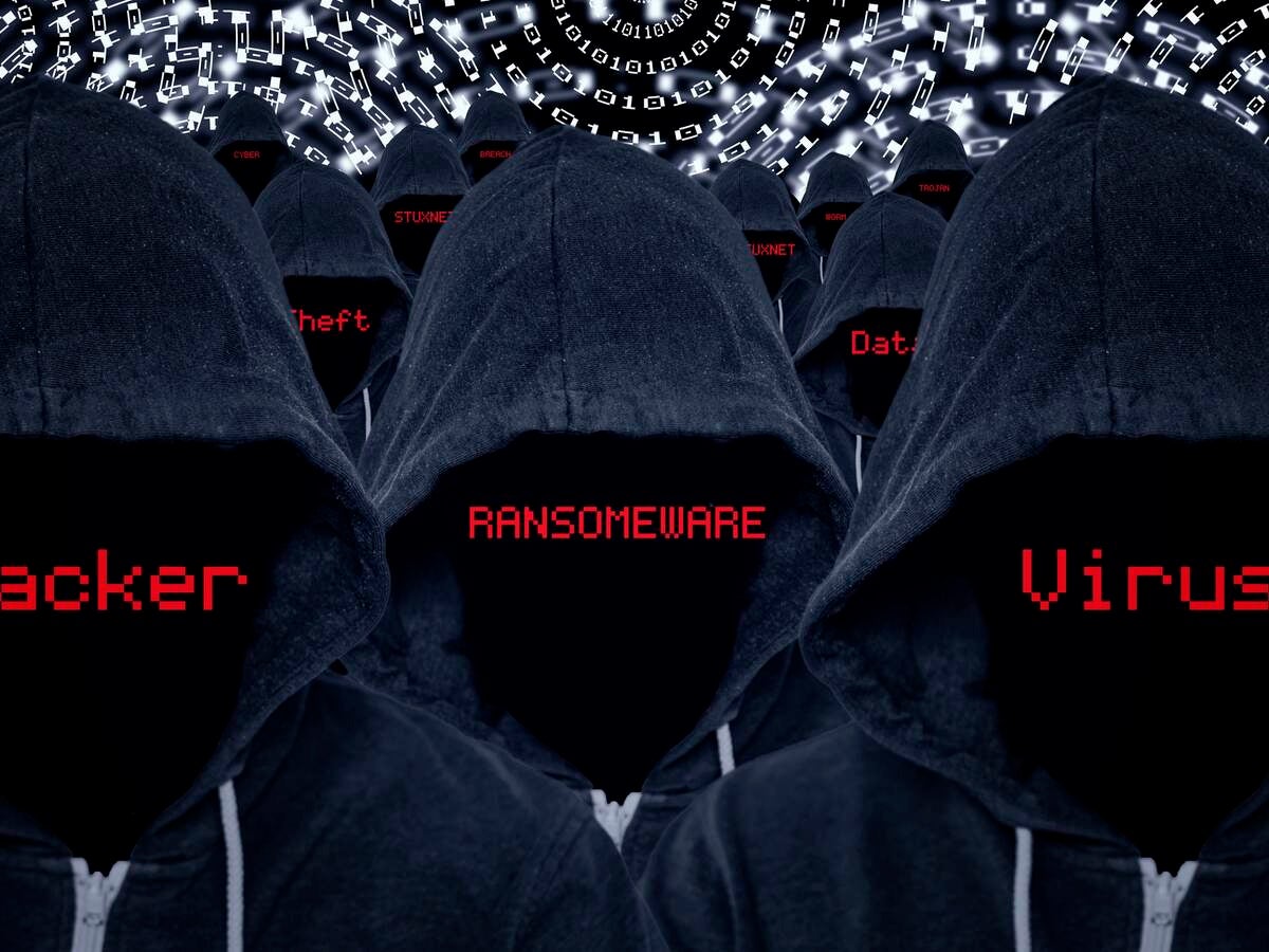 Mass of hooded computer criminals with various internet attacks and criminal activities in red text with a binary code background