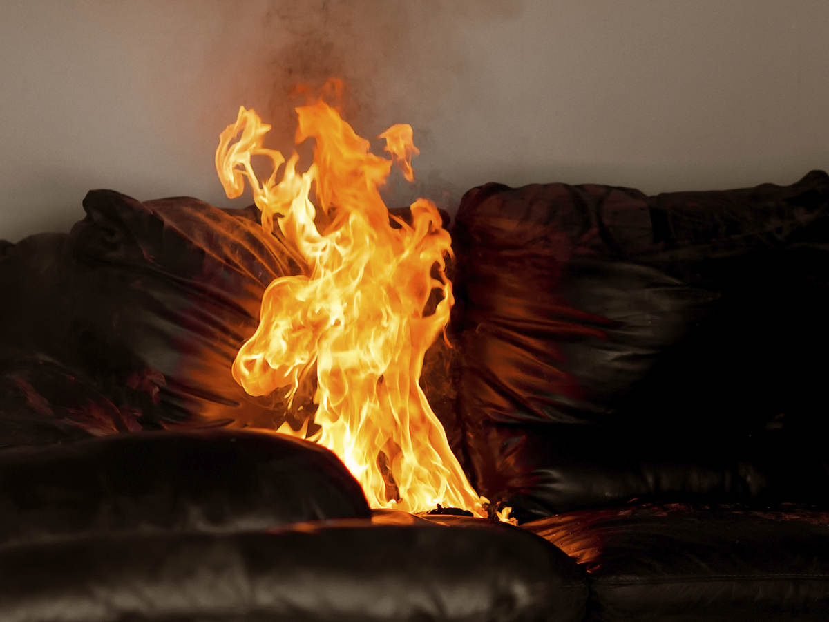 A flame rises off of a couch.