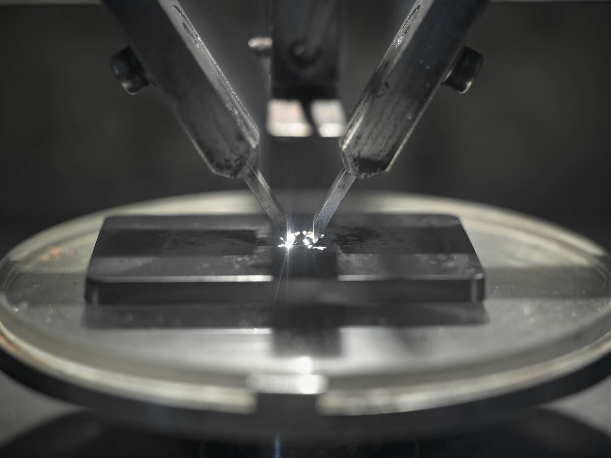 A close-up image of a machine testing a piece of plastic. 
