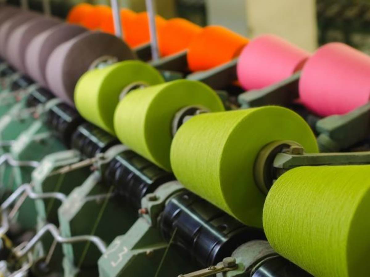 Textile industry - yarn spools on spinning machine in a textile factory