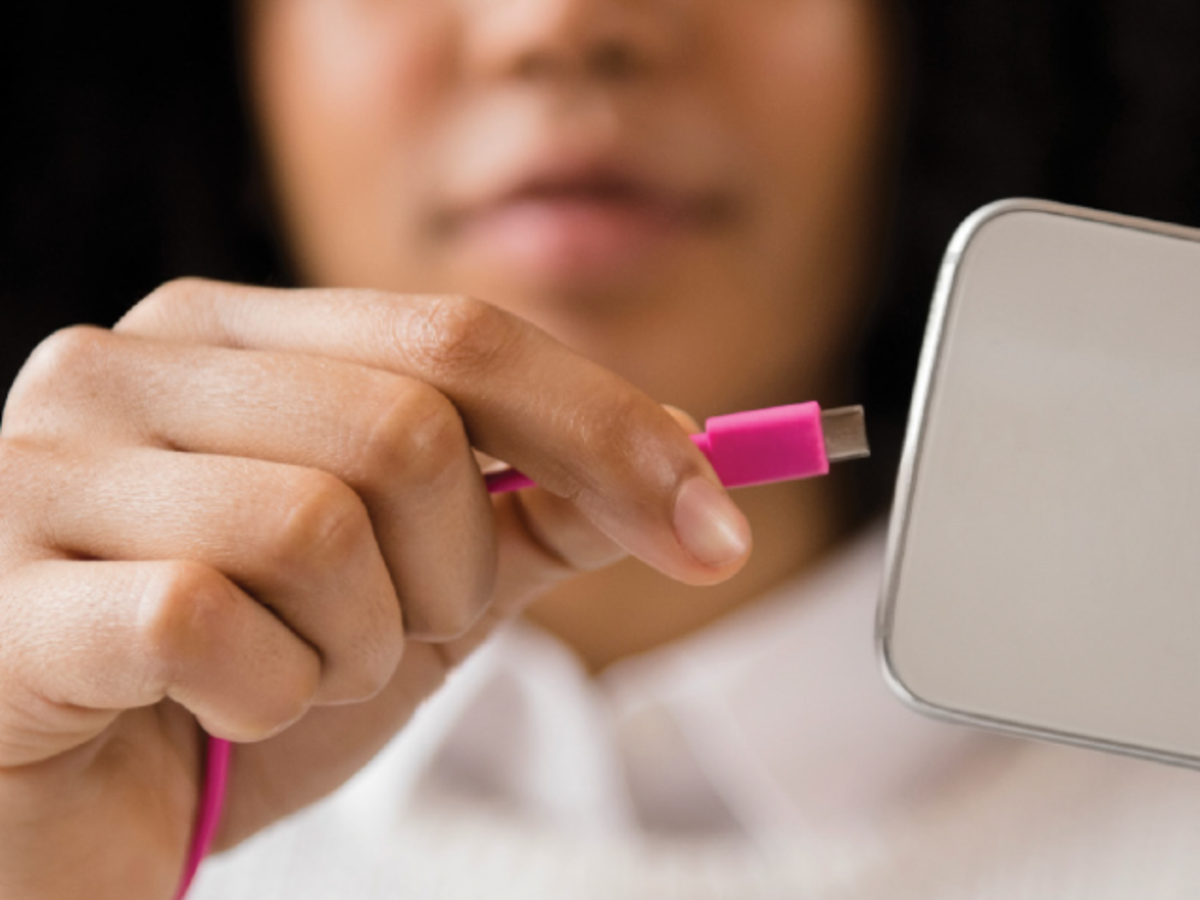 Woman plugging power cord into phone