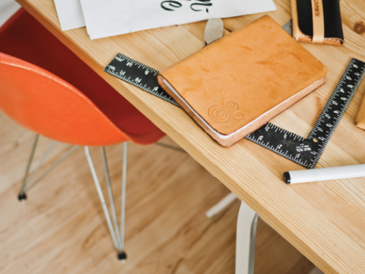 Overhead shot of table and chair with notebook/ruler