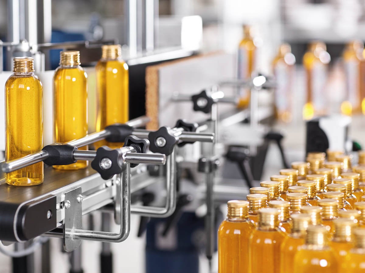 Bottles filled with liquid moving through the manufacturing process.