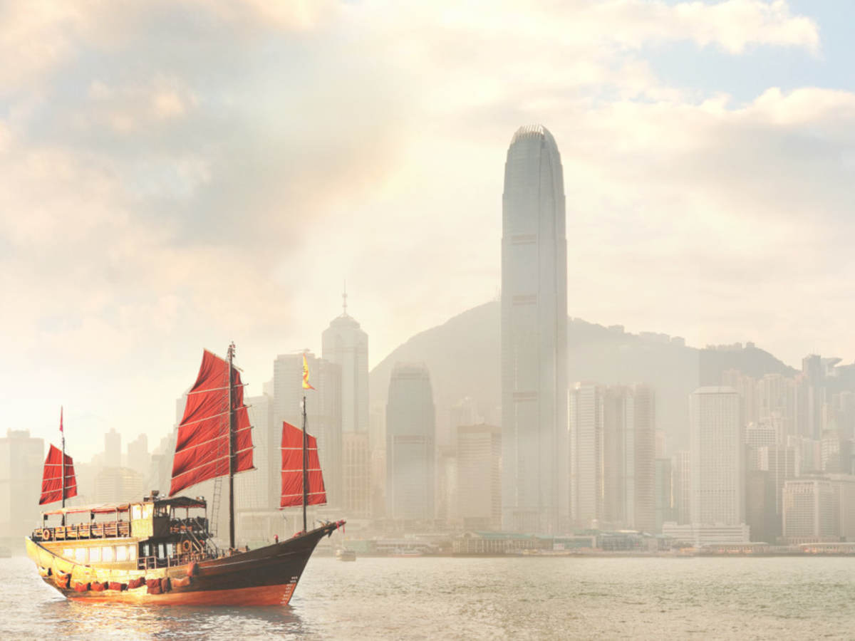 A boat sailing in front of a large city.