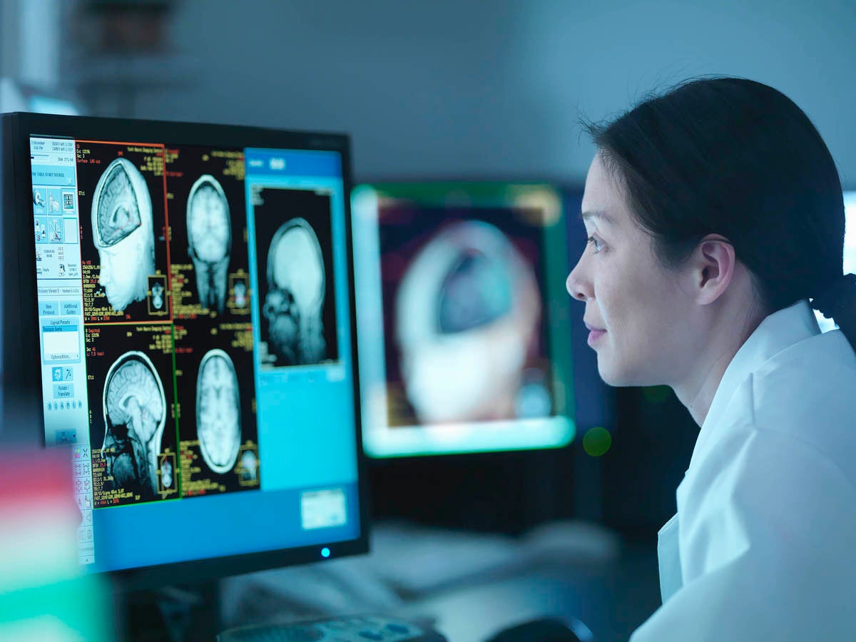 Woman in front of screen with medical scans  