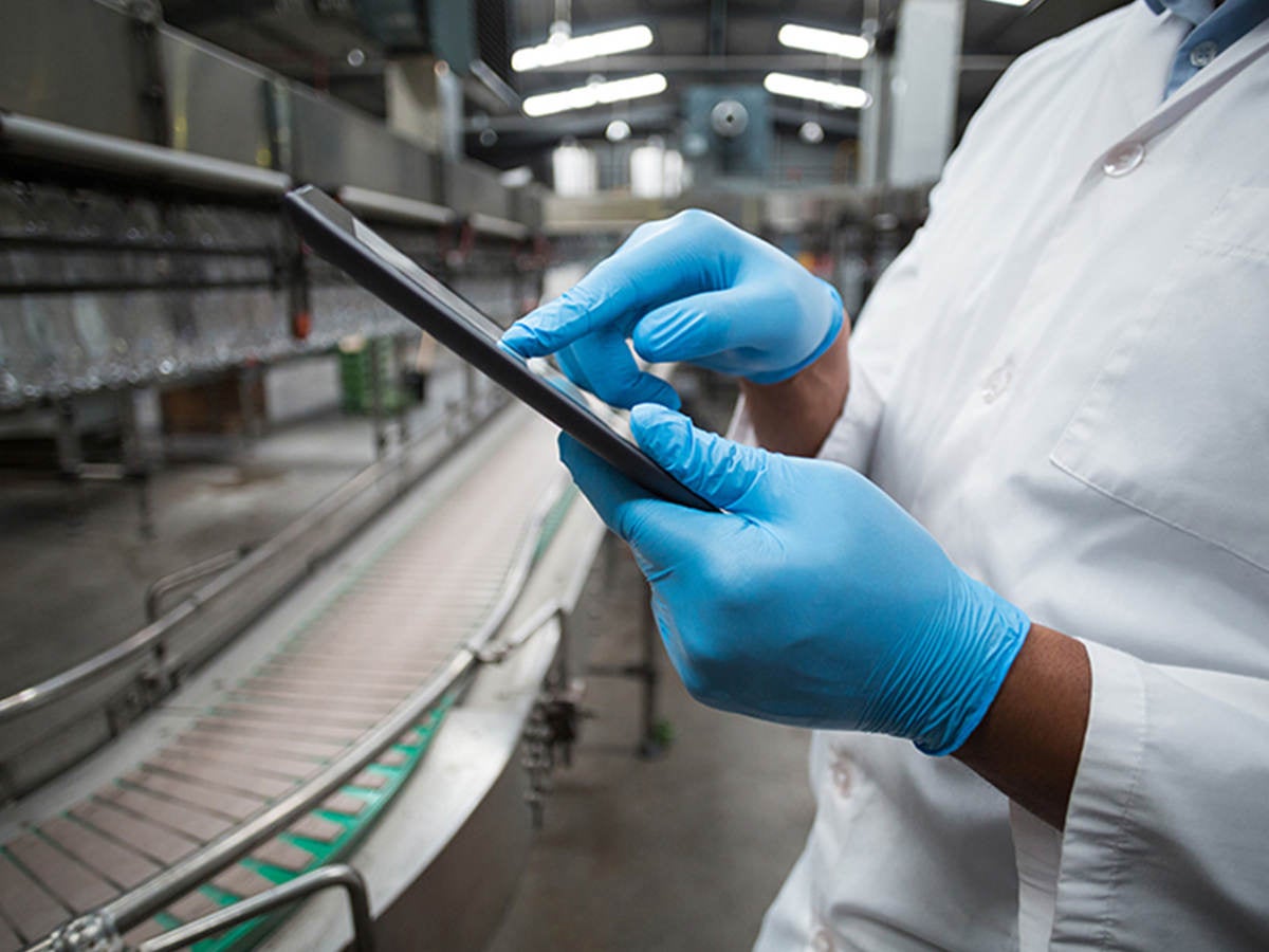 A worker checks a tablet computer.  