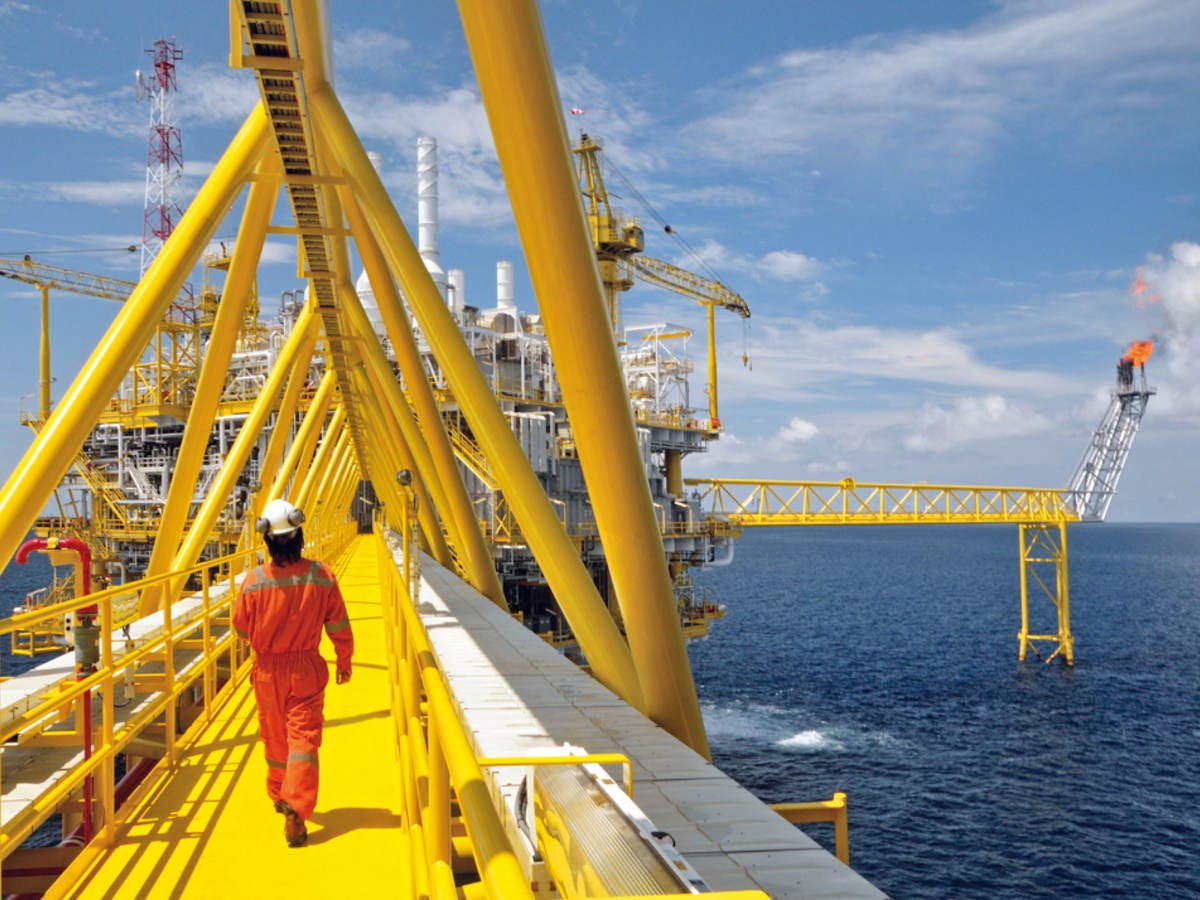 A worker walking on a platform of an offshore rig. 