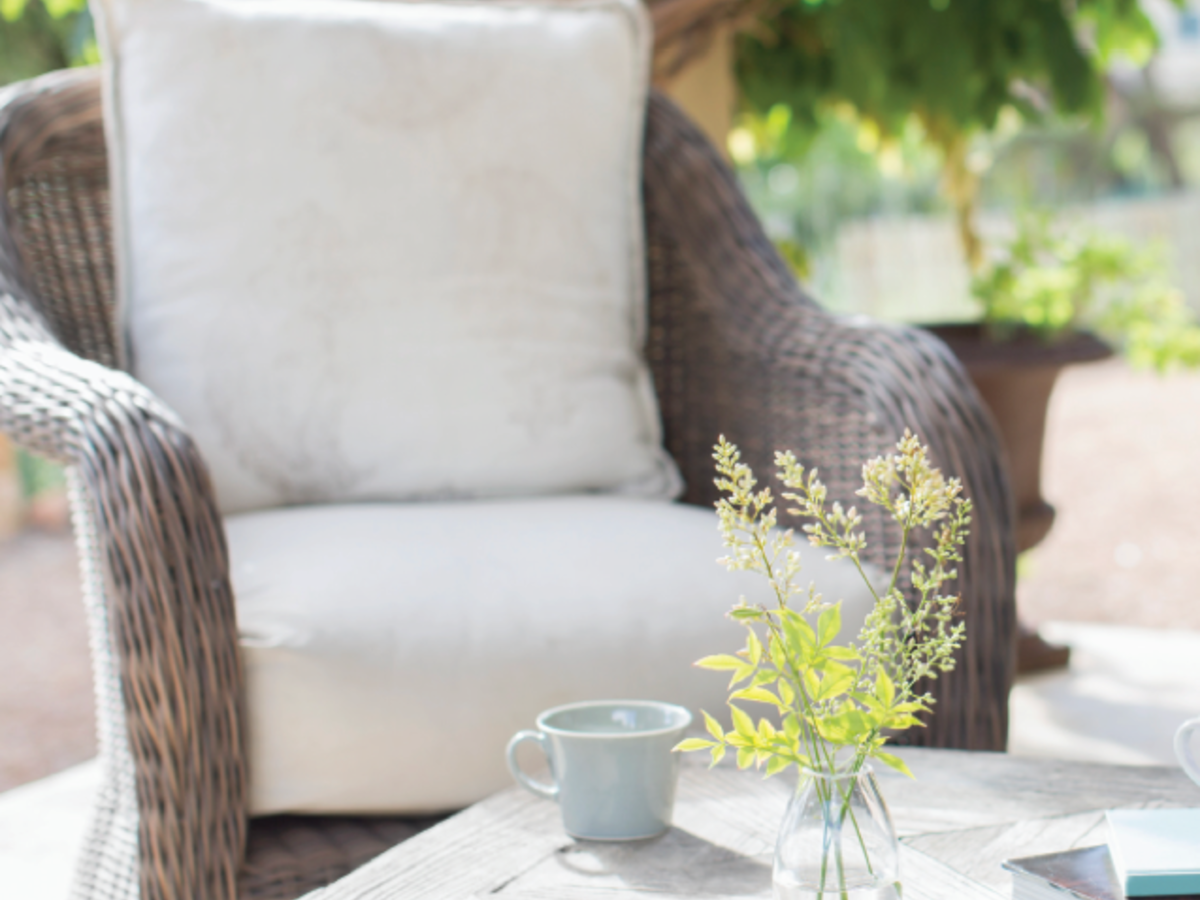 Wicker chair with cushions by coffee table outdoors