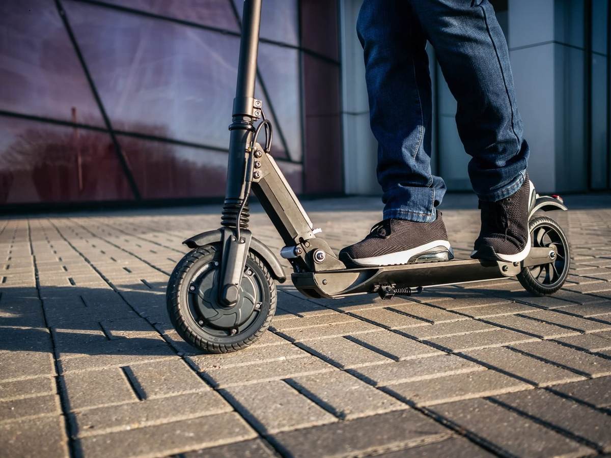 close up view of the legs of a man on an electric scooter.