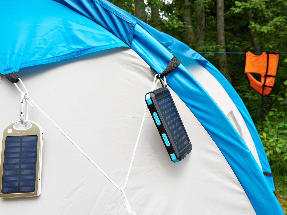 Grey tent with blue roof holds some type of solar panel used to recharge devices.