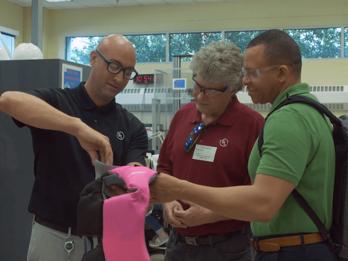 UL staff examines the updated label on a pink life jacket at our Research Triangle Park facility