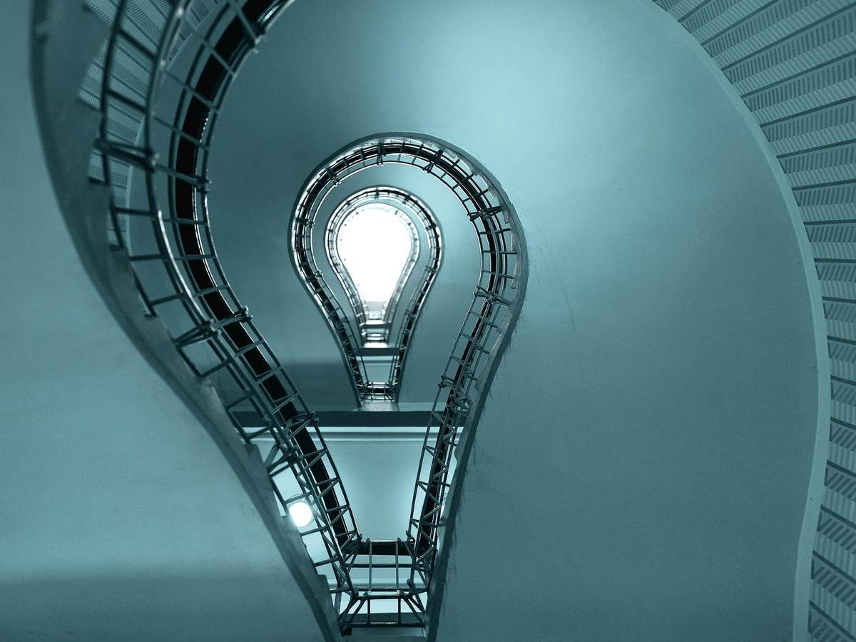 A light bulb sits at the bottom of a circular staircase.