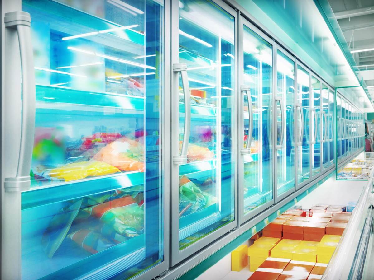 A row of supermarket freezers filled with all types of refrigerated food.