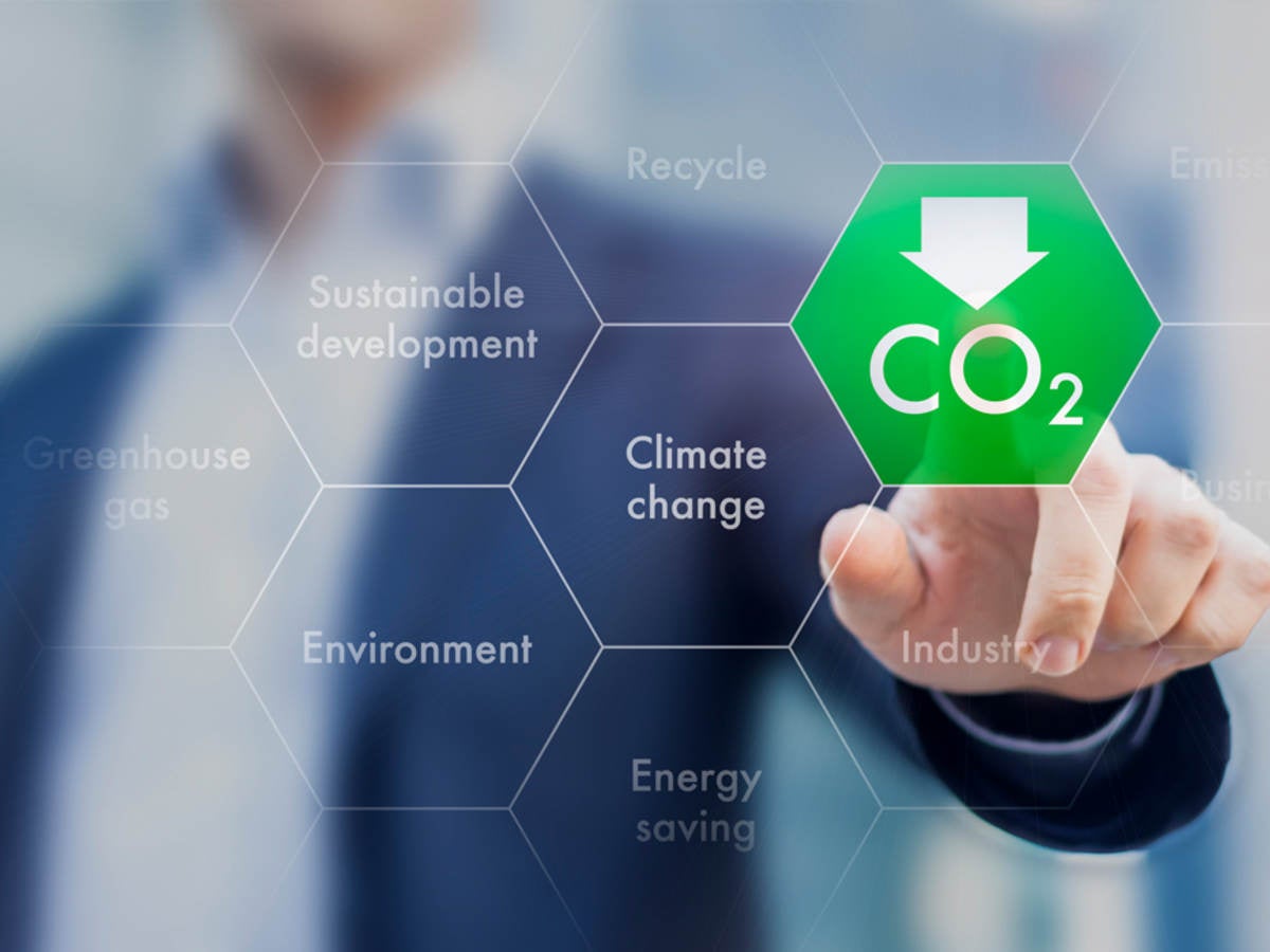 Man in suit jacket touching a CO2 icon with his fingertip to indicate embodied carbon.