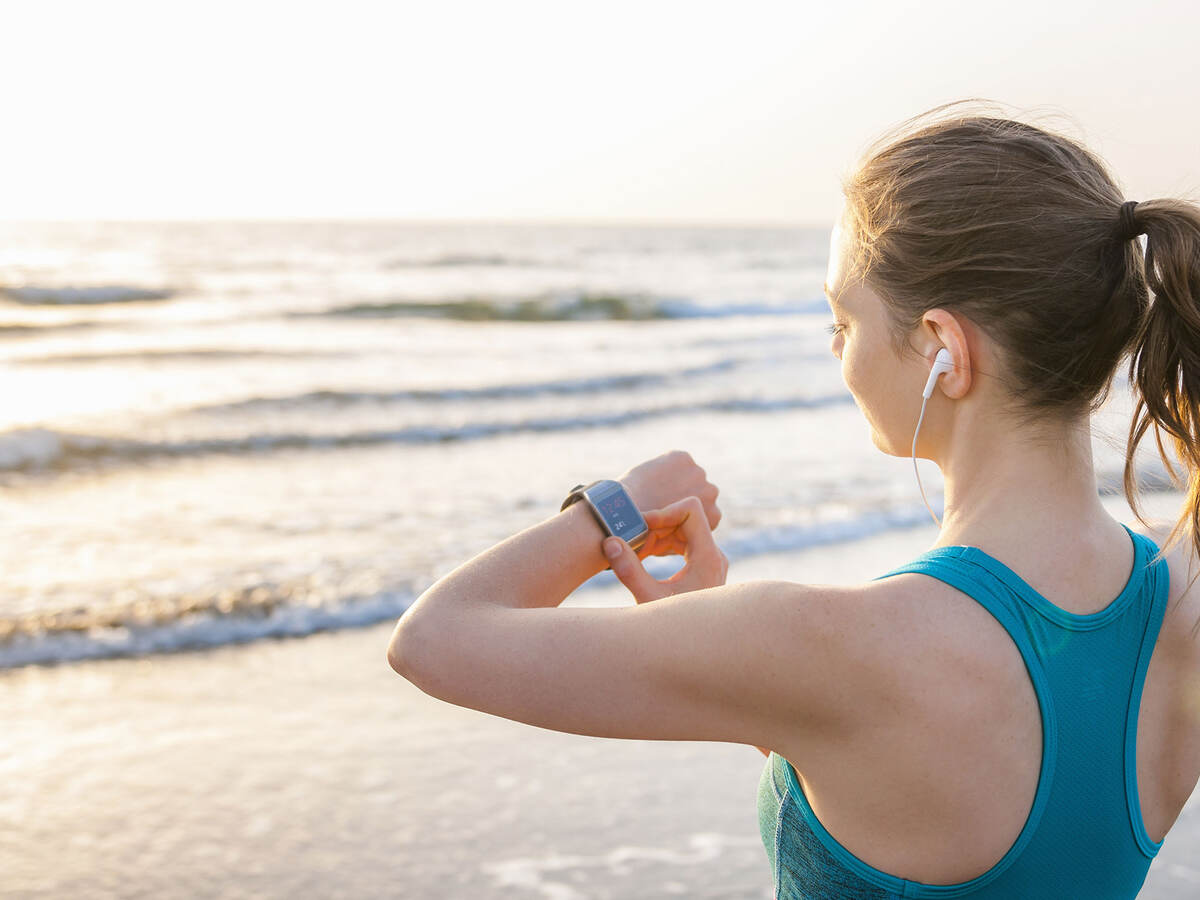 woman working out, looking at smartwatch