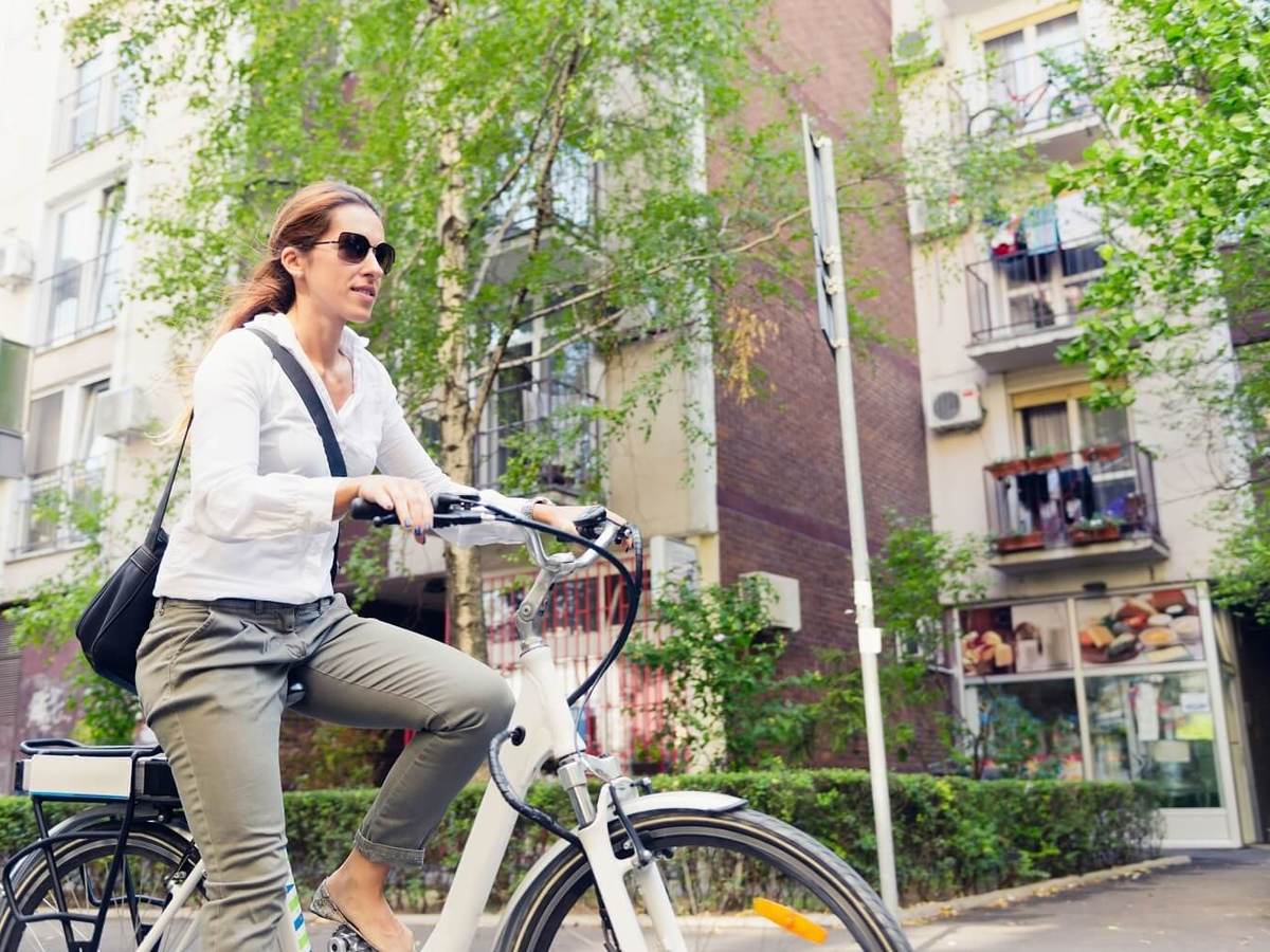 E-bike commuter, riding through a city block