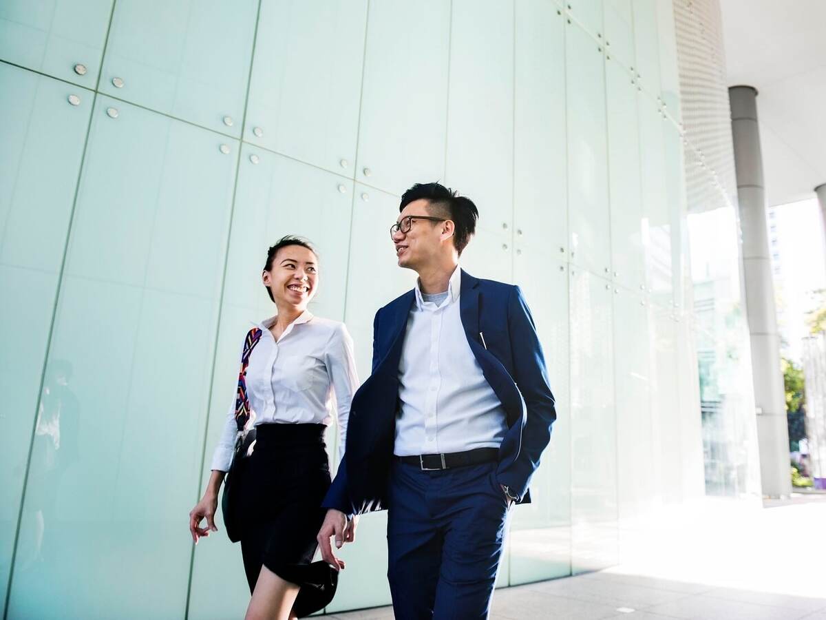 Asian business people discussing while walking
