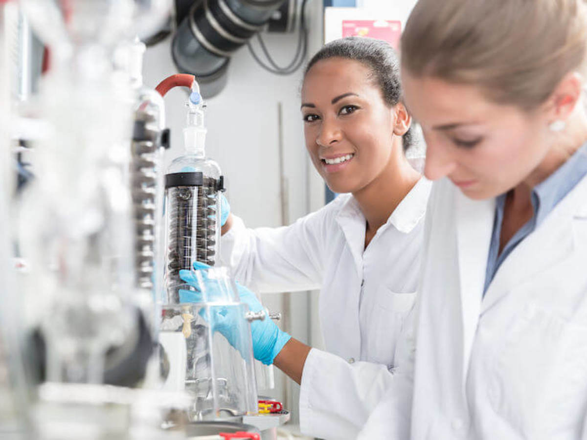 Group of scientists working with gloves and gowns in laboratory.
