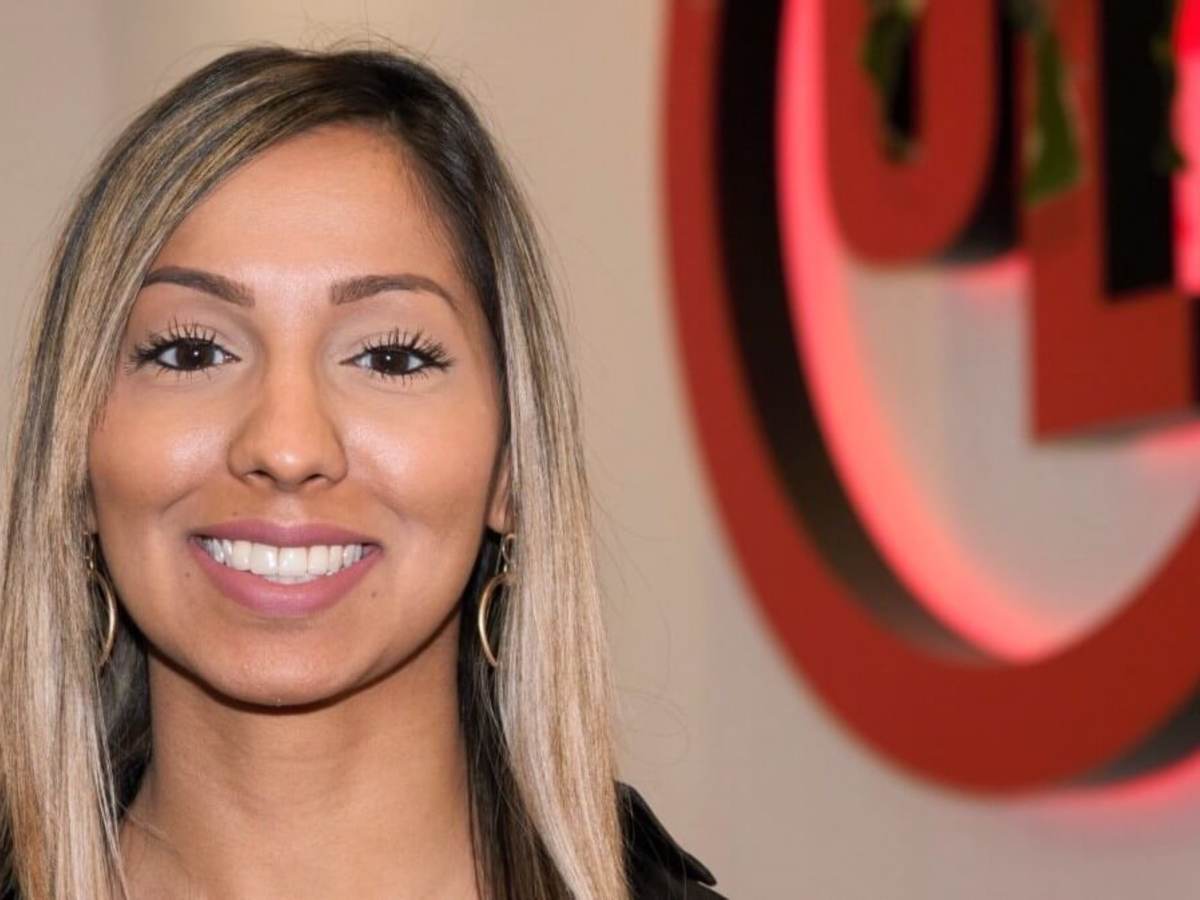Sharika Chowdhury poses to the side of the UL logo in her New York office.